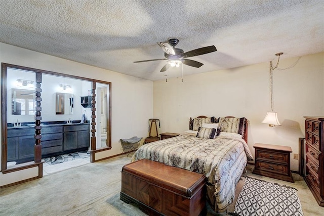 bedroom featuring sink, ensuite bath, light carpet, a textured ceiling, and ceiling fan