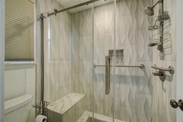 bathroom featuring toilet and an enclosed shower