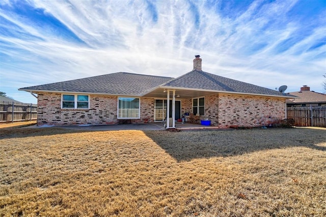 rear view of house with a yard and a patio