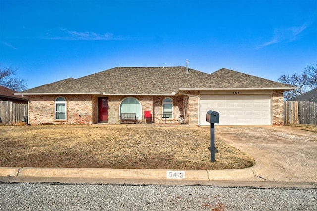 ranch-style house featuring a garage and a front lawn