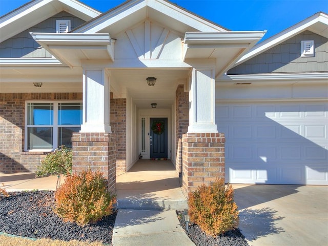 view of exterior entry with covered porch and a garage