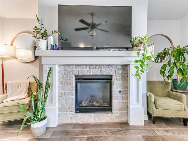 interior details with ceiling fan and a fireplace