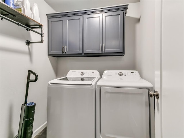 washroom with cabinets and washing machine and clothes dryer