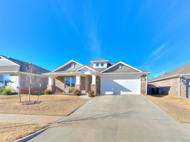 craftsman-style home with brick siding, a front lawn, concrete driveway, and a garage