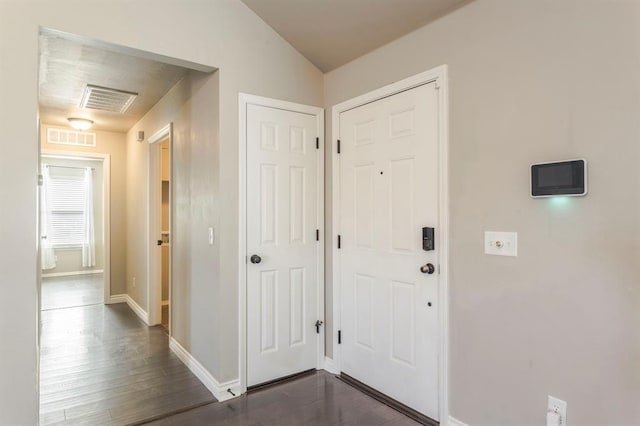 interior space with vaulted ceiling and dark hardwood / wood-style floors