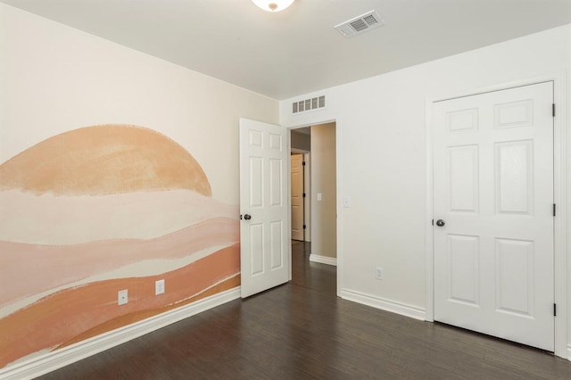 unfurnished bedroom with dark wood-type flooring and a closet