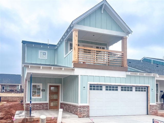 view of front of house featuring a balcony, a shingled roof, board and batten siding, and brick siding