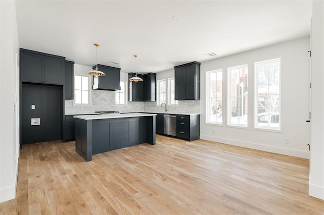 kitchen with tasteful backsplash, light wood-type flooring, a wealth of natural light, and light countertops