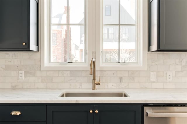 kitchen featuring a sink, tasteful backsplash, gray cabinets, and stainless steel dishwasher