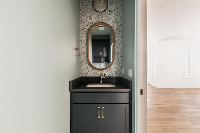 bathroom featuring baseboards, wood finished floors, and vanity