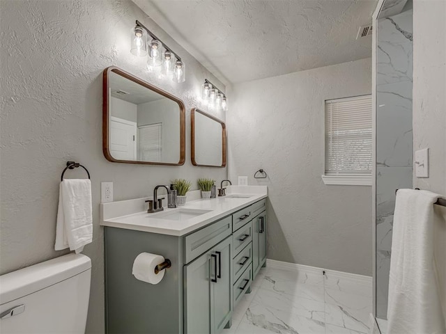 bathroom with vanity, a textured ceiling, and toilet