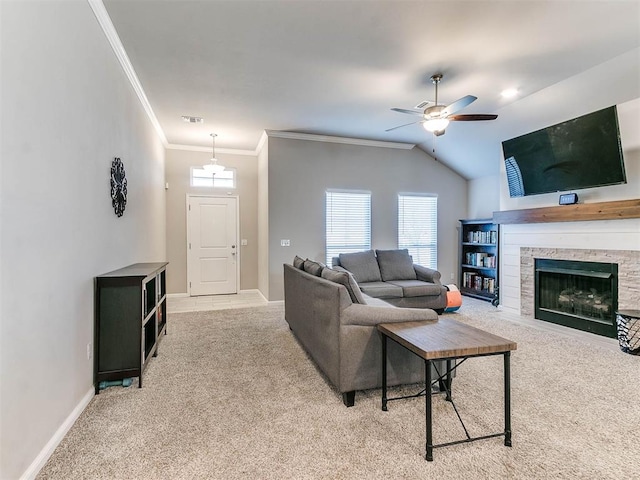 living room featuring ceiling fan, a stone fireplace, lofted ceiling, light carpet, and ornamental molding