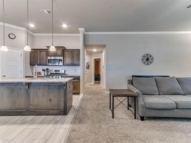 kitchen featuring decorative light fixtures, dark brown cabinets, light stone countertops, and stainless steel appliances