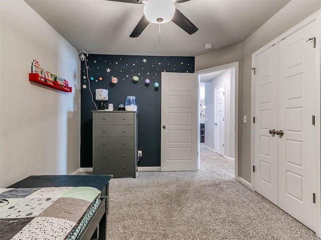 carpeted bedroom with ceiling fan and a closet