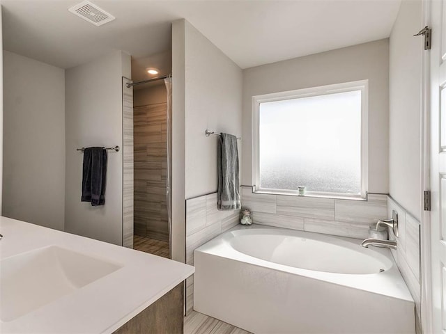 bathroom with sink and shower with separate bathtub