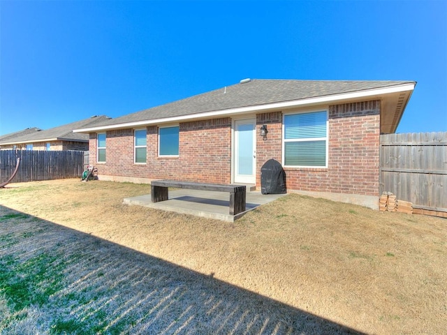 back of property featuring a patio and a lawn