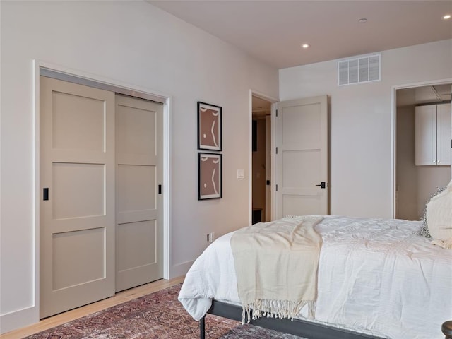 bedroom featuring hardwood / wood-style floors and a closet