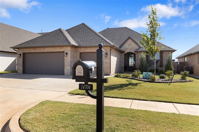 french country home featuring a front yard, concrete driveway, an attached garage, and a shingled roof