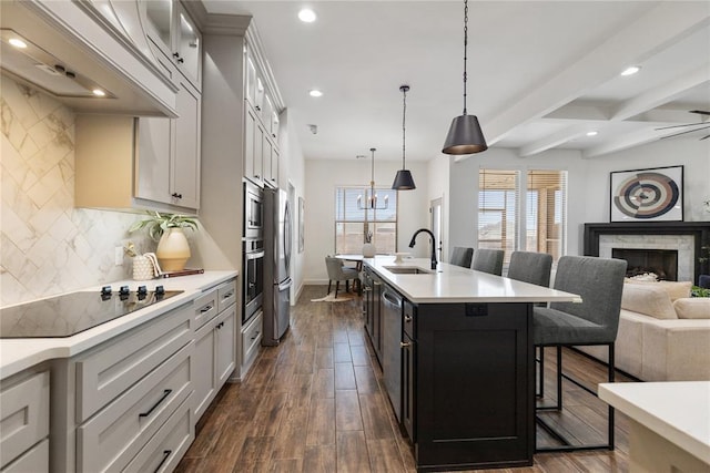 kitchen with open floor plan, a breakfast bar area, light countertops, custom exhaust hood, and stainless steel appliances