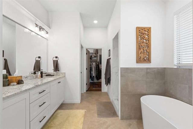 14704 Ashore Dr, Oklahoma City, OK 73142 - full bath with vanity, a spacious closet, tile patterned flooring, a freestanding bath, and tile walls