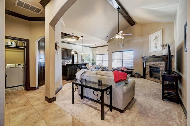 living room with a fireplace, light colored carpet, ceiling fan with notable chandelier, and beamed ceiling