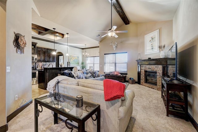 living room with ceiling fan with notable chandelier, light carpet, beamed ceiling, high vaulted ceiling, and a brick fireplace