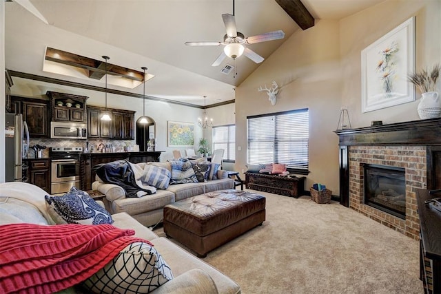 living room with light carpet, lofted ceiling with beams, a brick fireplace, and ceiling fan with notable chandelier