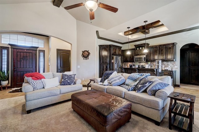 living room featuring ceiling fan and lofted ceiling with beams