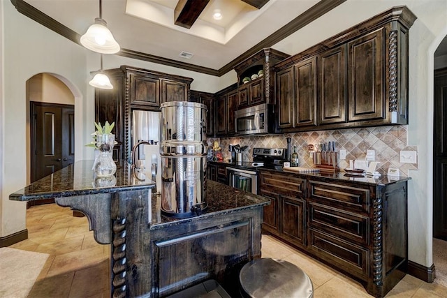 kitchen with dark stone countertops, dark brown cabinetry, a kitchen island with sink, appliances with stainless steel finishes, and a breakfast bar area