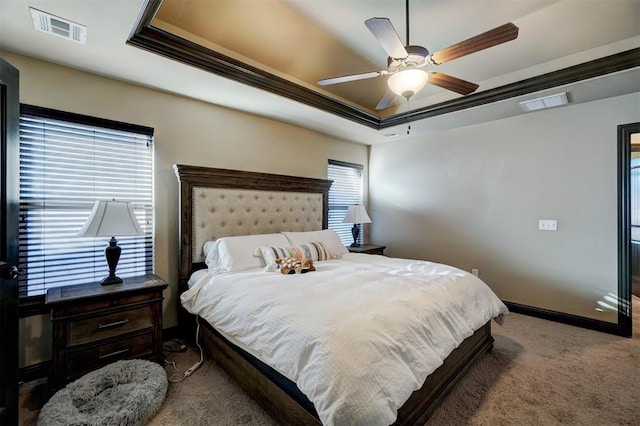 carpeted bedroom with ceiling fan, a tray ceiling, and ornamental molding