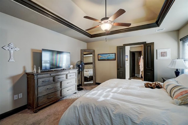 carpeted bedroom featuring ceiling fan, a tray ceiling, and crown molding