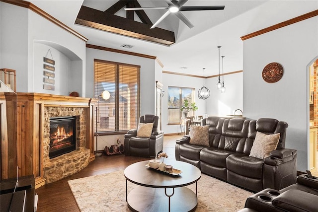 living room featuring a stone fireplace, crown molding, vaulted ceiling, dark hardwood / wood-style floors, and a notable chandelier