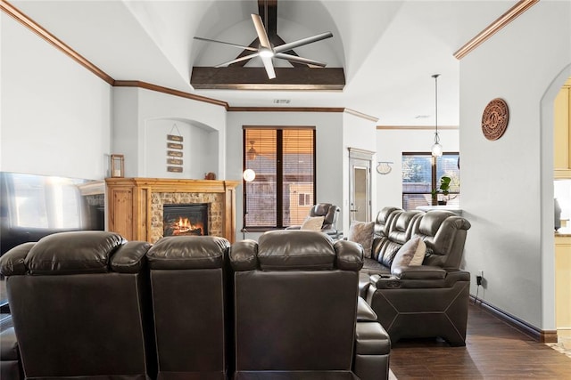 living room featuring vaulted ceiling, a stone fireplace, dark hardwood / wood-style floors, ornamental molding, and ceiling fan