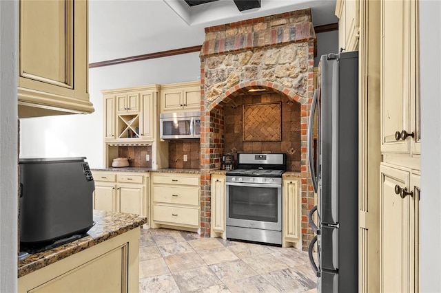 kitchen with cream cabinets, crown molding, stone counters, and appliances with stainless steel finishes