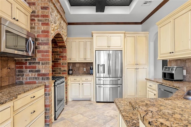 kitchen featuring cream cabinets, decorative backsplash, ornamental molding, and appliances with stainless steel finishes