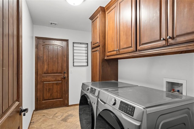 washroom with washing machine and dryer and cabinets