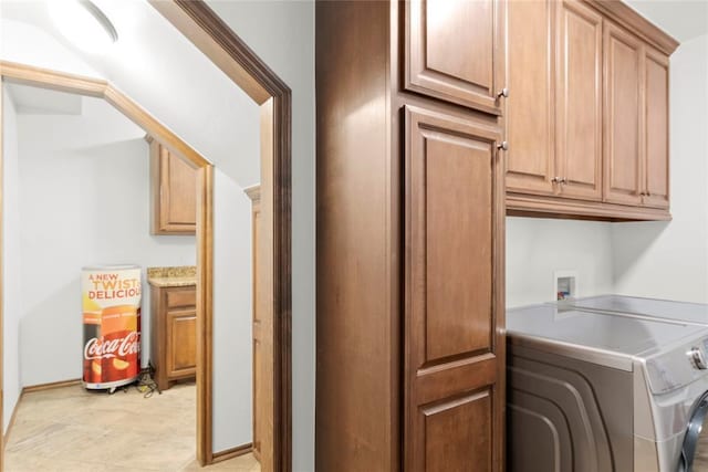 clothes washing area featuring independent washer and dryer and cabinets