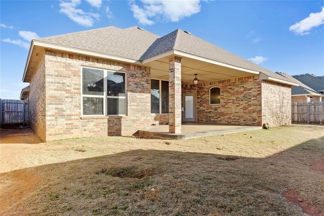 rear view of property featuring a yard and a patio area