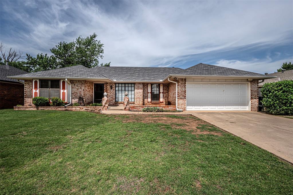 ranch-style house featuring a front yard and a garage