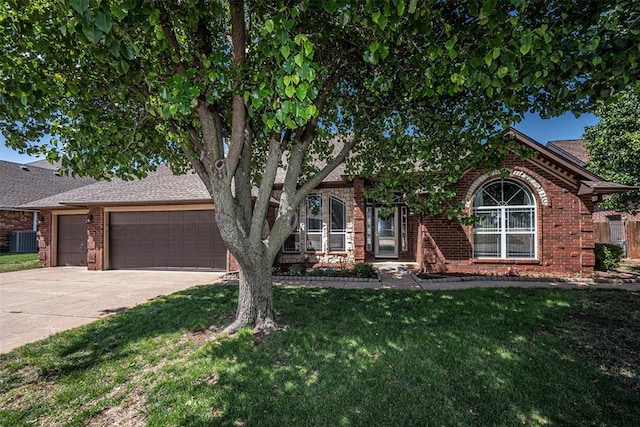 view of front of property featuring central AC unit, a garage, and a front yard