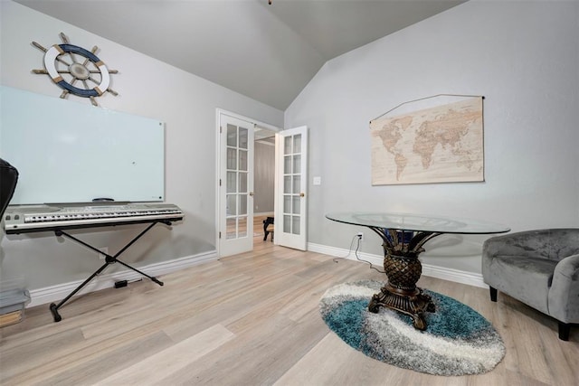 sitting room featuring light hardwood / wood-style floors, vaulted ceiling, and french doors