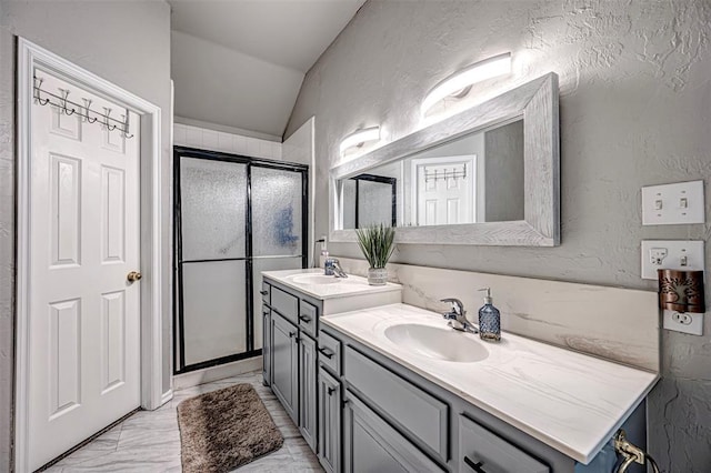 bathroom featuring vanity, vaulted ceiling, and a shower with shower door