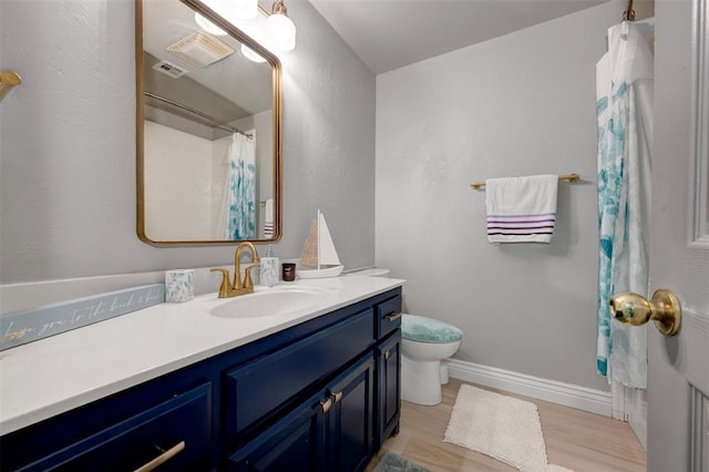 bathroom with hardwood / wood-style floors, vanity, and toilet