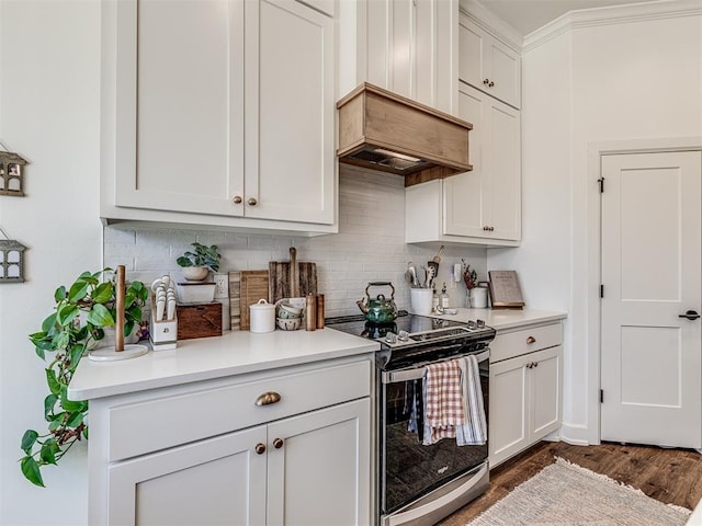 kitchen featuring premium range hood, stainless steel range with electric stovetop, white cabinetry, tasteful backsplash, and dark hardwood / wood-style flooring