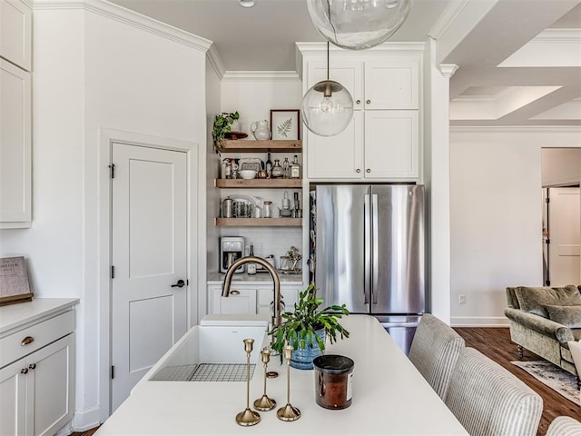 kitchen with pendant lighting, white cabinets, and stainless steel refrigerator