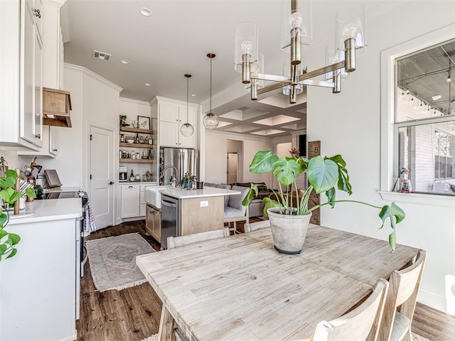 dining space featuring ornamental molding, sink, a chandelier, and dark hardwood / wood-style flooring