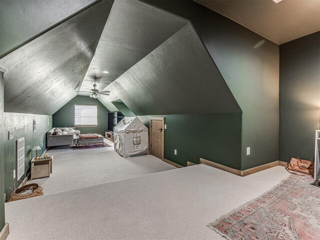 carpeted bedroom featuring lofted ceiling, a textured ceiling, and ceiling fan