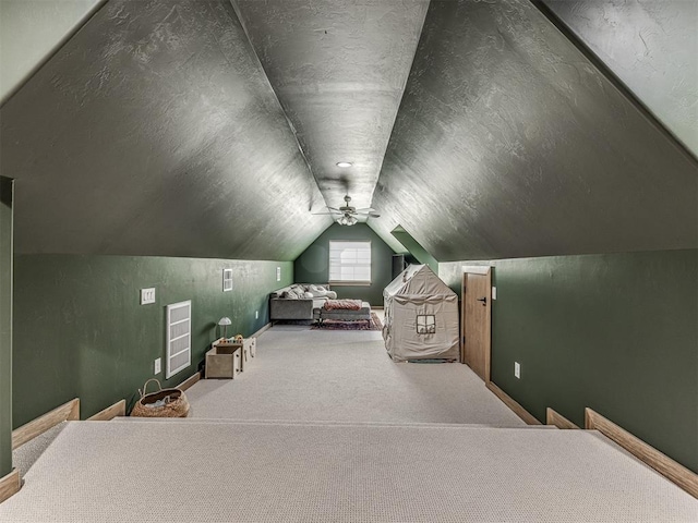 bedroom featuring lofted ceiling, carpet floors, a textured ceiling, and ceiling fan