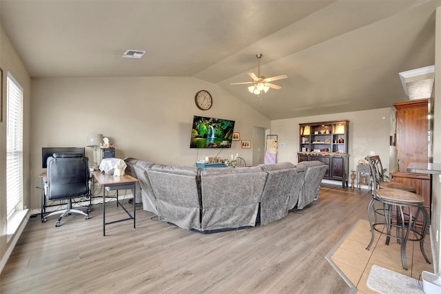 living room featuring ceiling fan, lofted ceiling, and light hardwood / wood-style flooring