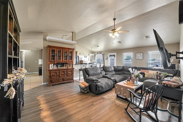 living room with hardwood / wood-style flooring, ceiling fan, and lofted ceiling